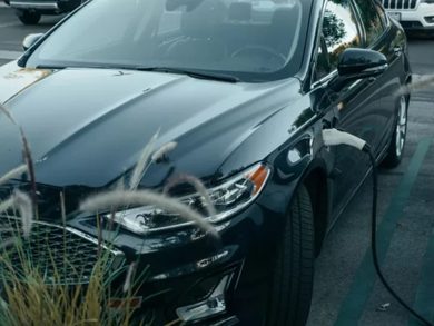 An image that shows an Ev charger plugged in black car